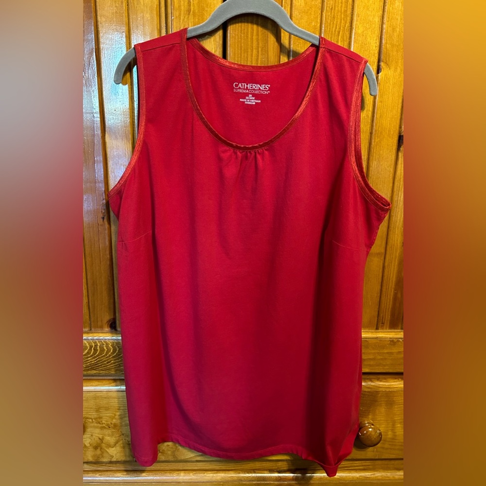 Red sleeveless tank top with satin trim around neck and arm holes.